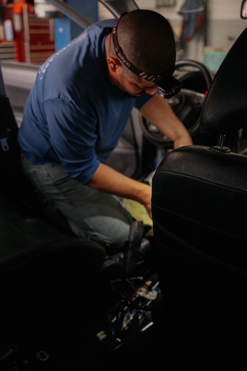 Technician cleaning car interior in the shop