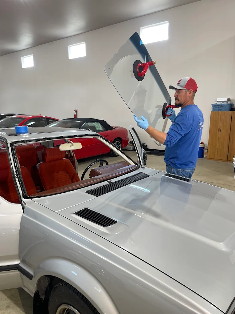 Technician installing windshield on classic Honda Prelude with suction cups