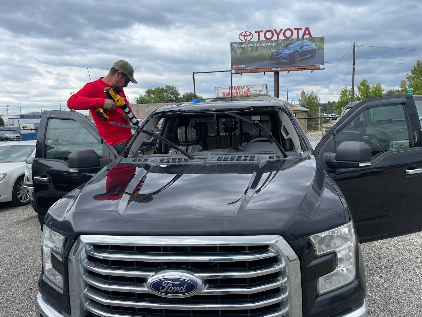 Technician removing windshield from Ford F-150 before ADAS recalibration